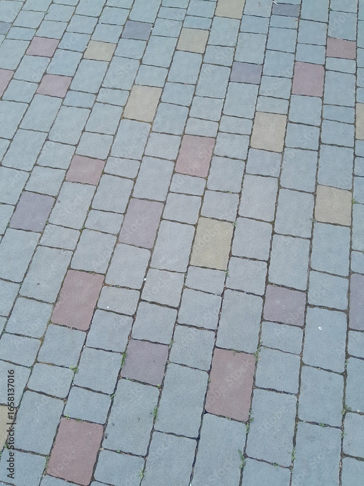 Fototapeta premium Texture of street tiles. Pattern of gray sidewalk tiles close up