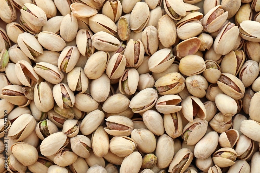 Tasty unpeeled pistachios as background, top view flat lay background Tasty unpeeled pistachios as background, top view flat lay background