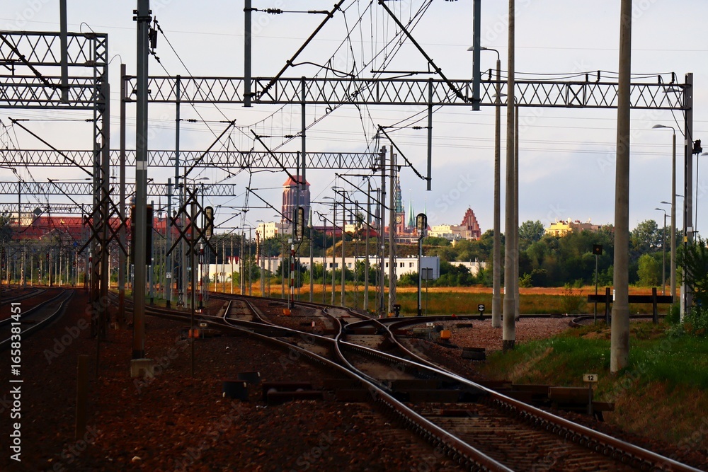 Obraz premium railway tracks and a view of the towers of the monuments of the city of Gdańsk in the distance, Poland