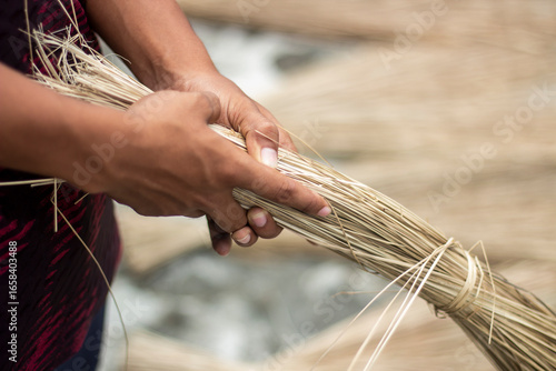 Persons hands holding a bundle of dry natural fibers, ready for processing