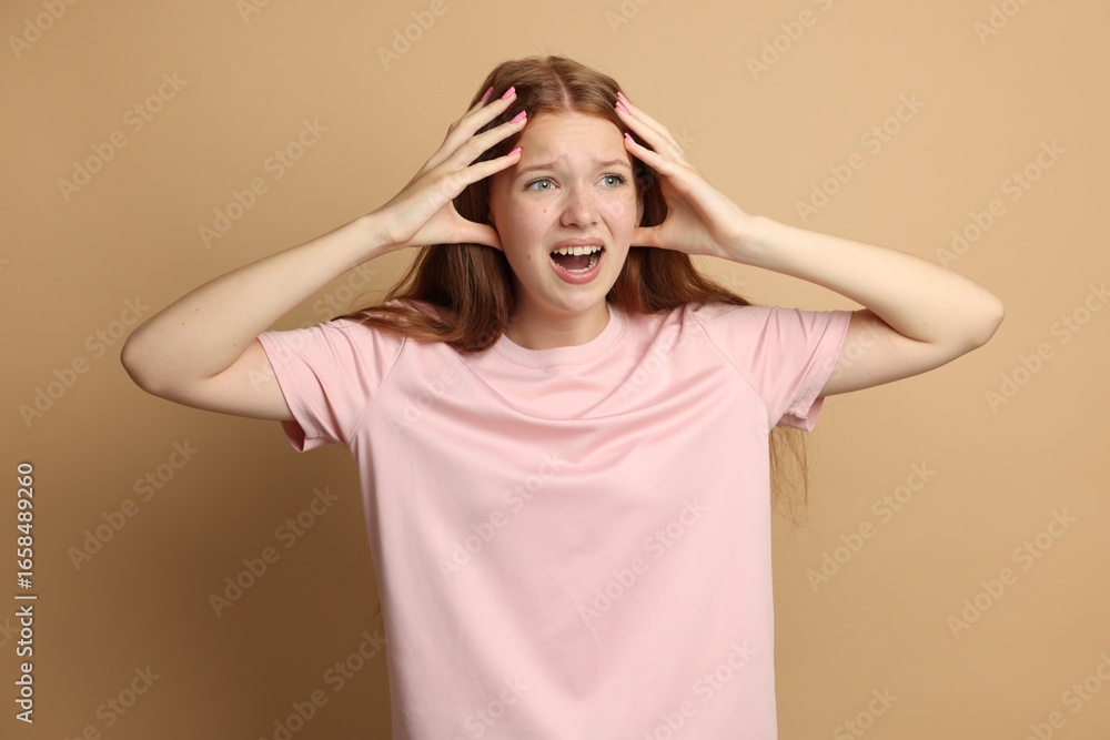 Teenage girl suffering from panic attack on beige background Teenage girl suffering from panic attack on beige background