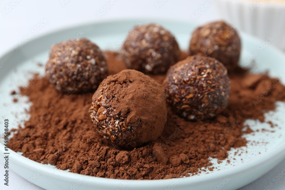 Delicious homemade candies with cocoa powder on table, closeup Delicious homemade candies with cocoa powder on table, closeup