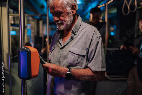 Senior man using smartphone to pay public transport fare