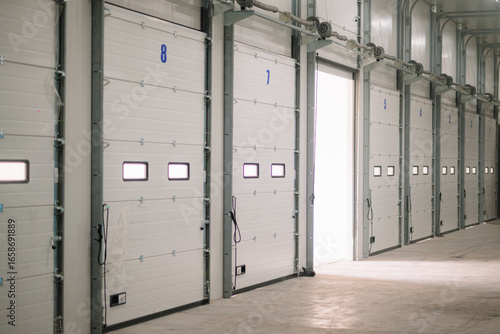 Papier peint Interior view of a modern warehouse loading bay with multiple numbered sectional overhead doors