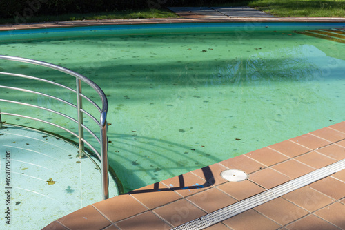 Dirty swimming pool with leaves in the pool bottom. Cleaning concept