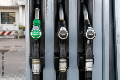 Fuel pump nozzles at a gas station showing unleaded petrol (Senza Piombo) and diesel options in Italy