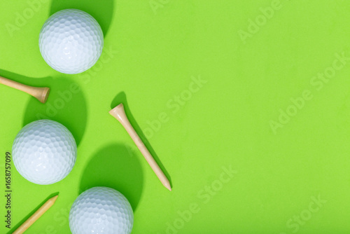 Golf background. Group of golf balls and tee on green background