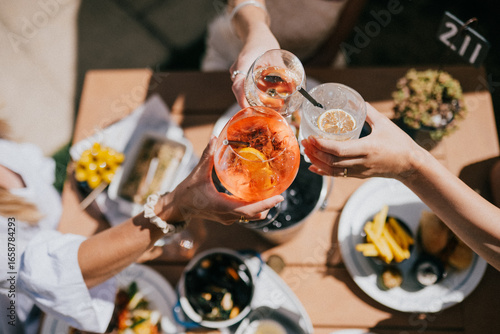 A group of people are celebrating with drinks and food