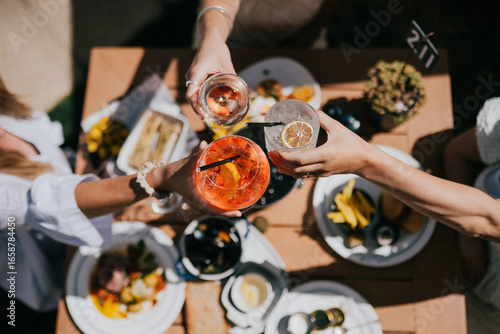 A group of people are celebrating with drinks and food