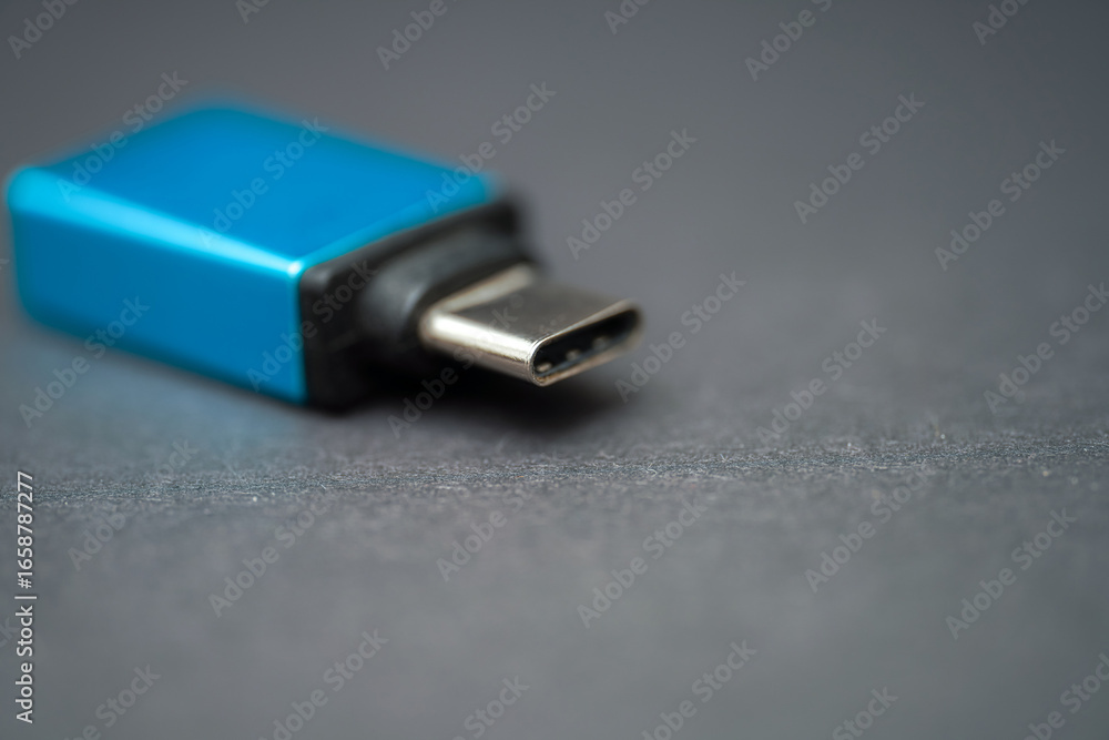 USB-C adapter rests on a dark surface while showcasing its sleek design and functionality for modern devices USB-C adapter rests on a dark surface while showcasing its sleek design and functionality for modern devices