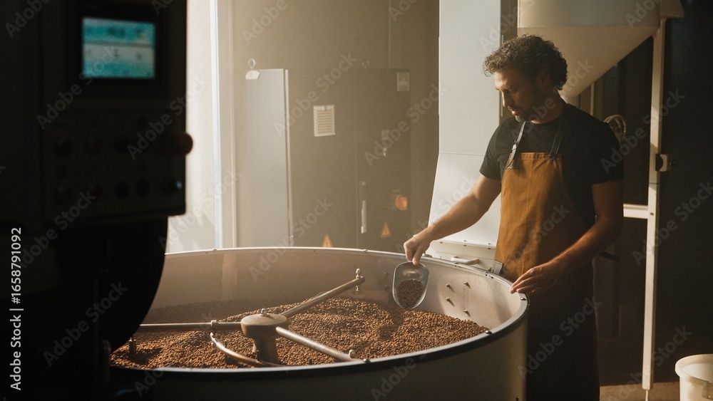 custom made wallpaper toronto digitalCaucasian male with curly hair wearing brown apron standing near large roasting drum. Scooping freshly roasted coffee beans. Inspecting batch quality while working in sunlit coffee production room.