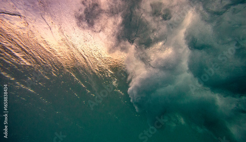 Photography Underwater view of water surface below surfing wave breaking in bubbles and foam