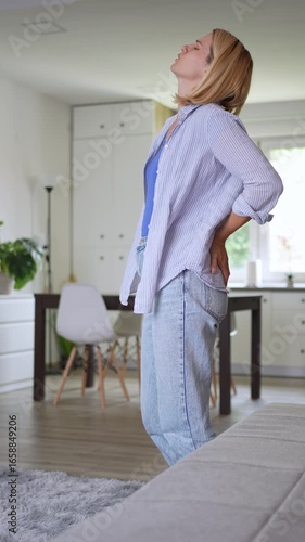 Woman suffering back and hip pain at home