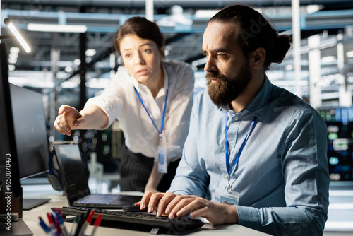 Tableau sur toile Programmers in data center workplace using computer, verifying firewall configurations