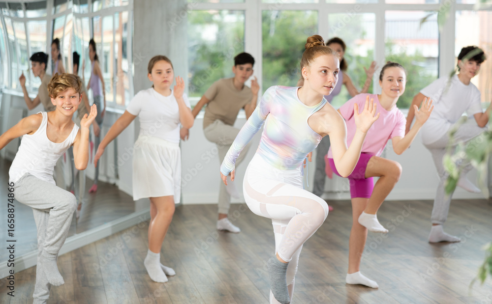 Fototapeta premium Group of boys and girls rehearsing dancehall dance in studio