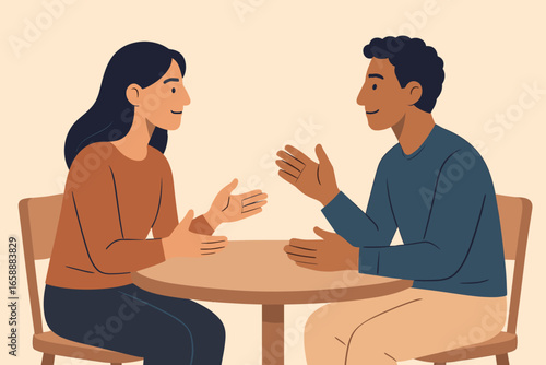 A pair of people sit across from each other at a round table, deep in conversation. Their body language is open and attentive, suggesting a meaningful