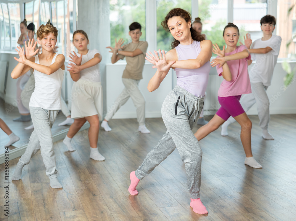 Naklejka premium Group of boys and girls rehearsing jazz funk dance in studio