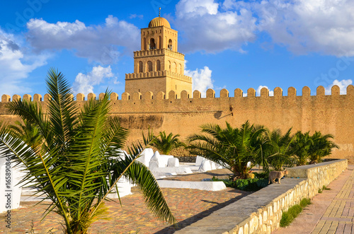 The city walls of Kairouan, with a cemetery visible in front of them, and the Great Mosque also known as the Mosque of Uqba in the background, Tunisia.