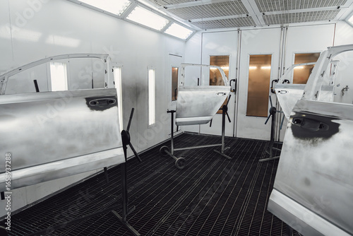 Parts of auto painting in chamber. Metal part of frame car. Auto spare parts. Painting car parts. Automotive paint services, quality auto body shop.