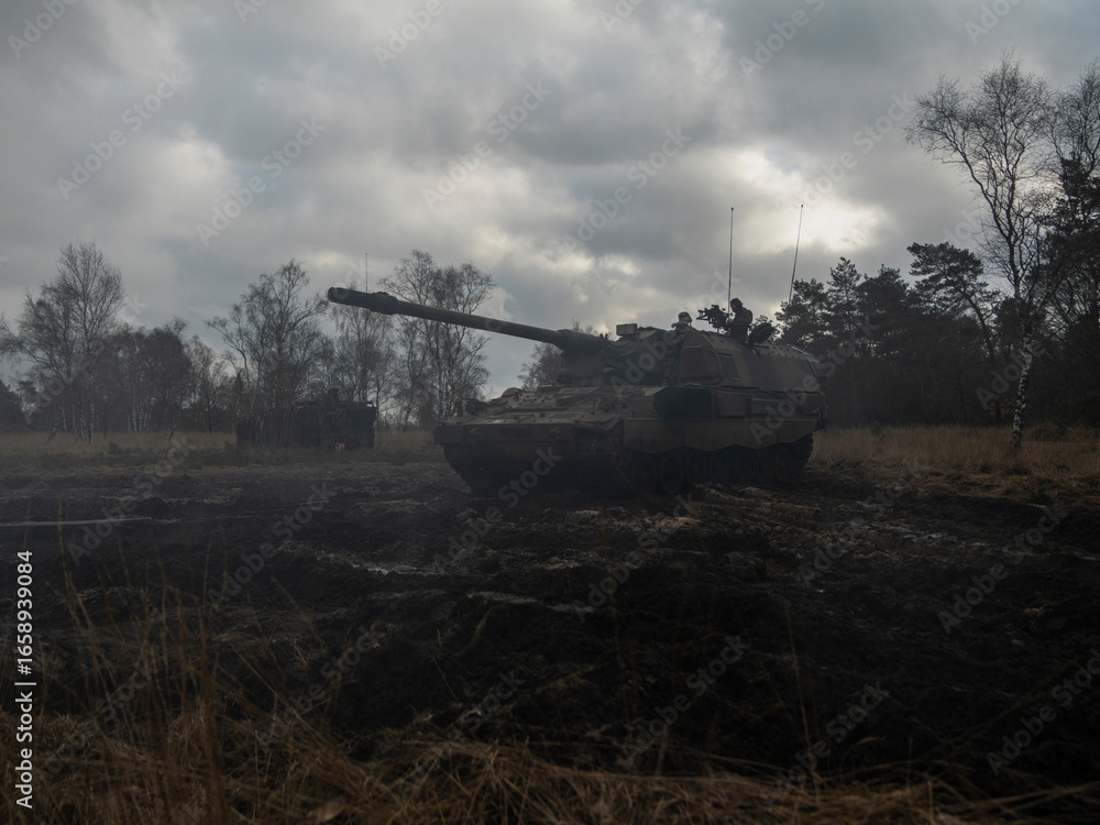 Fototapeta premium Military tank with crew members in field setting under cloudy sky