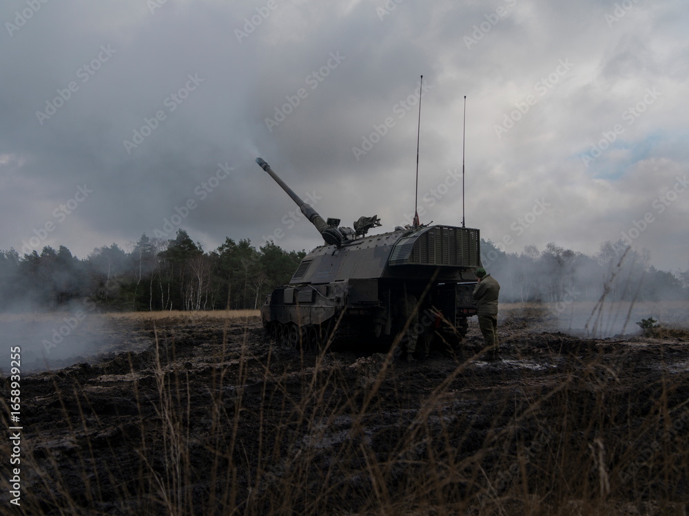 Fototapeta premium PZH2000NL artillery piece positioned in smoky field with atmospheric conditions