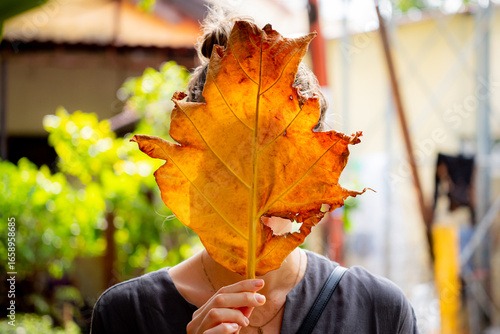 young woman with autumn leaves in the city of Hội An, Vietnam