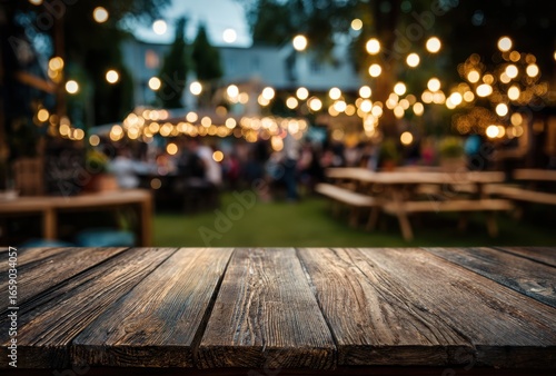 Outdoor evening scene of a lively outdoor dining area with string lights, wooden tables, and blurred patrons enjoying a social gathering under a canopy of warm glowing lights