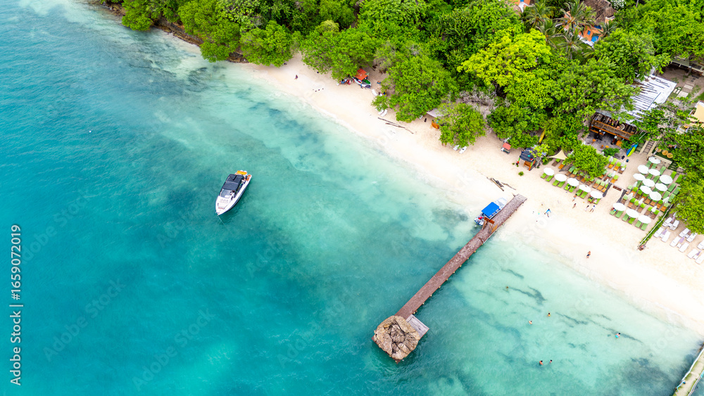 Fototapeta premium Stunning aerial shot of Rosario Island's beach, showcasing turquoise waters, lush greenery, and a wooden pier, perfect for travel and nature enthusiasts.