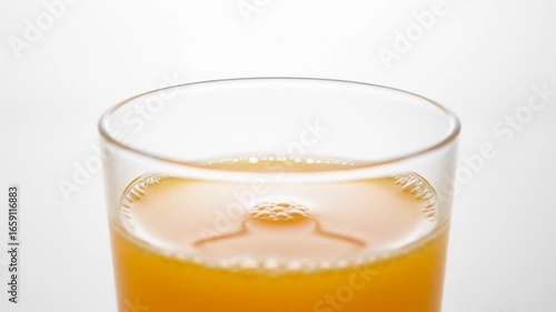 Refreshing Orange Juice in Glass with Bubbles on White Background Close Up