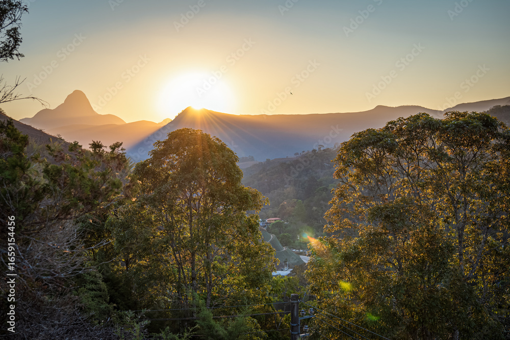 Obraz premium Mountain Silhouettes and Sun Rays at Sunset in Itaipava, Brazil