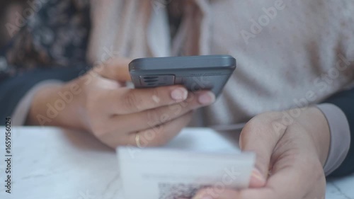 woman using a mobile device to scan QR code for cafe menu 