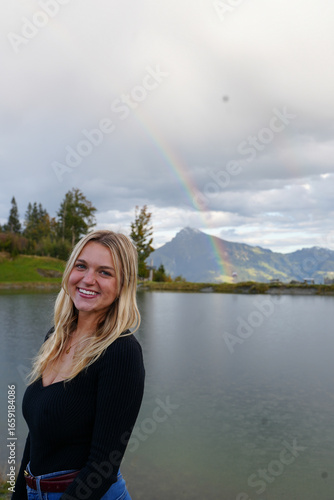 Girl in the Mountains in Front of a Lake with Rainbow