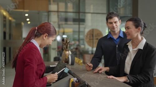 Hotel Receptionist Handing Key Card to Guest at Modern Lobby Front Desk During Check-In Process, Concept of Hospitality, Customer Service