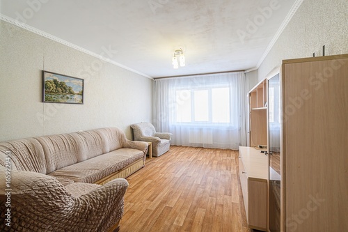 Fotografie living room with a sofa, armchair, cabinet, and window