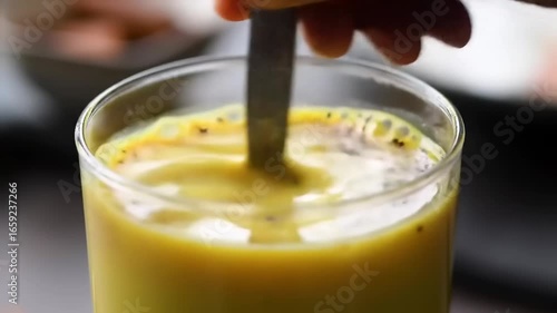 Hand stirring a golden drink