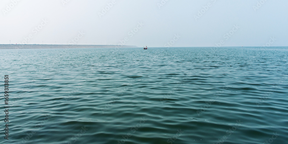 Naklejka premium Serene Ocean View With Calm Waves and Distant Boat Under Clear Sky