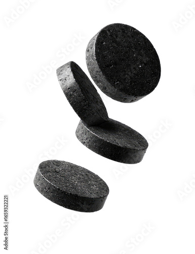 Dark gray circular tablets levitate against a black backdrop