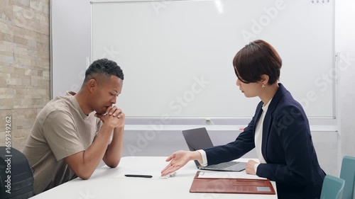 Wallpaper Mural A Japanese female staff member interviewing a troubled black man Torontodigital.ca