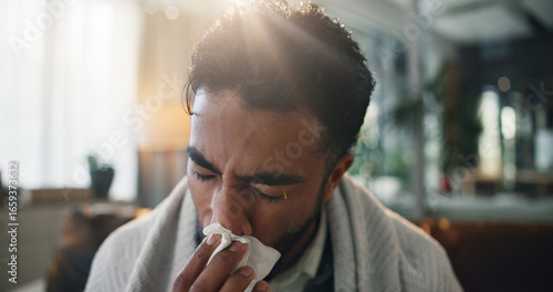 Photos Sick man, home or blowing nose with tissue for flu symptoms, cold or hayfever on sofa