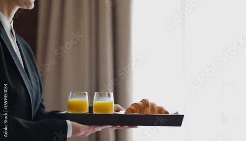 Professional Waitstaff Serving Breakfast with Orange Juice and Croissants
