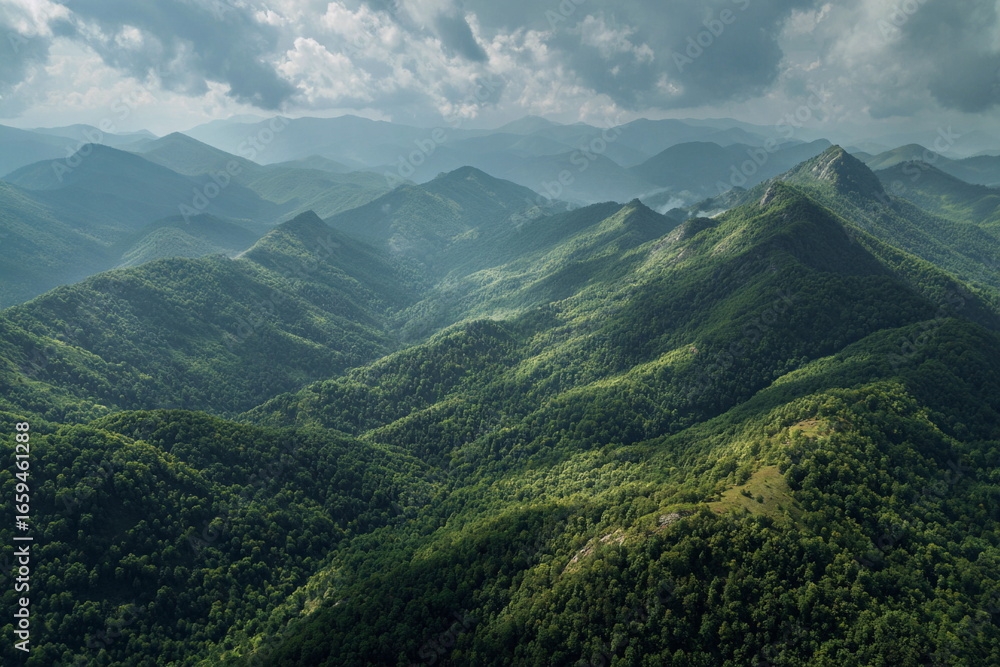 Fototapeta premium Panoramic view of green mountain valley with rolling hills and clouds, capturing wilderness, nature beauty, fresh air, travel inspiration and serenity