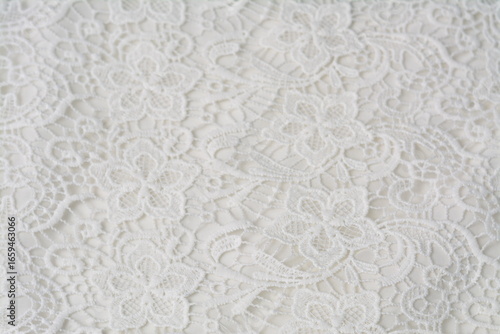 White lace with floral embroidery on soft textile surface