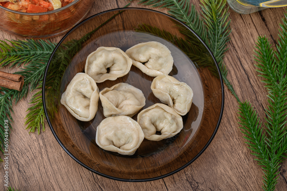 Fototapeta premium Cooked Christmas Eve dumplings stuffed with mushrooms placed on a plate on the holiday table