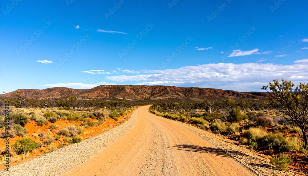 Fototapeta premium Dusty road stretching into a vast landscape under a vibrant sky