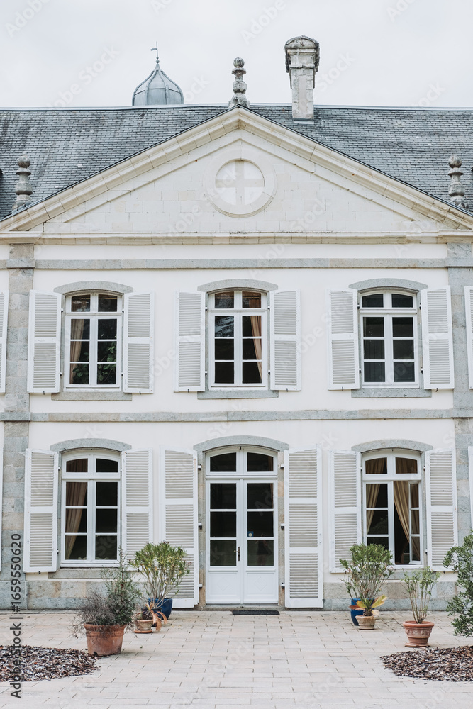 Obraz premium Front view of French château wedding venue with shutters and stone architecture