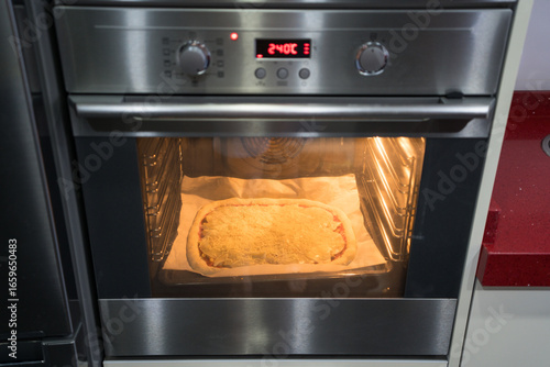 Pizza baking in home oven for a savory homemade meal