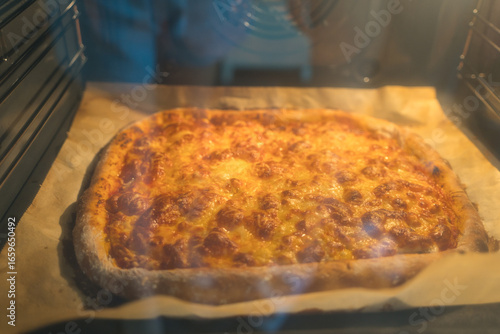 Homemade pizza baking in the oven viewed from inside