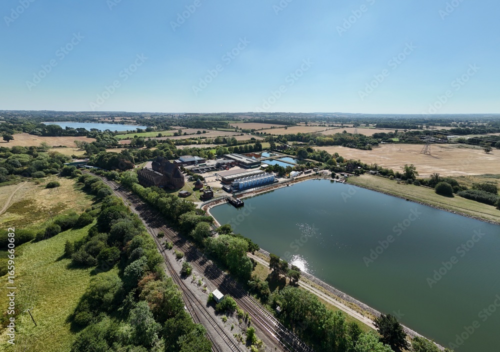 Fototapeta premium Aerial drone shot of wastewater sewage treatment plant, with storage silos and lake water, industrial removal of contaminants in Birmingham England UK
