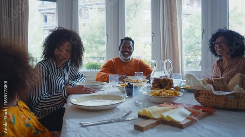 Storytelling image of a Family reunited at parents house for lunch on the holidays. Family members celebrating at home eating good food, sharing love and positive emotions