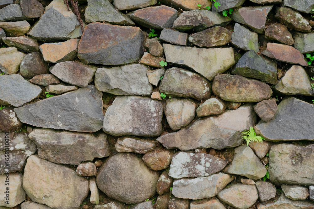 Fototapeta premium Stacked stone brick wall. Stone cladding wall made of striped stacked slabs of natural grey rocks. Pattern of decorative slate stone wall surface. Stone pattern background